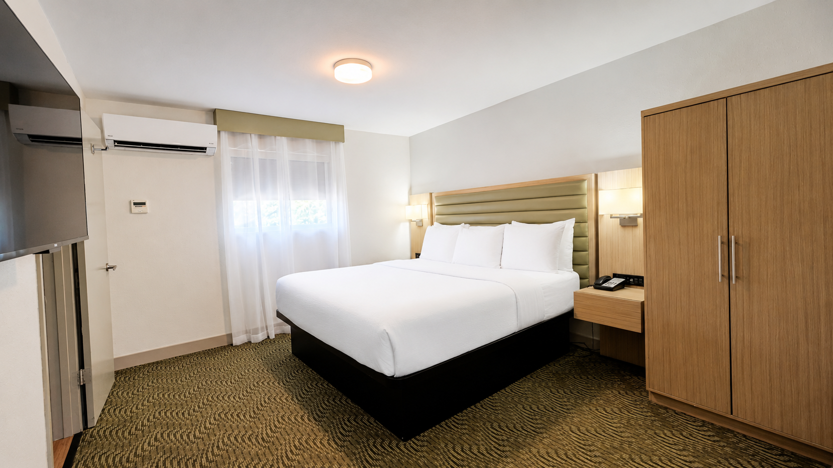 King bedroom in the Sedona View King Suite with wall-mounted TV and full-length wardrobe