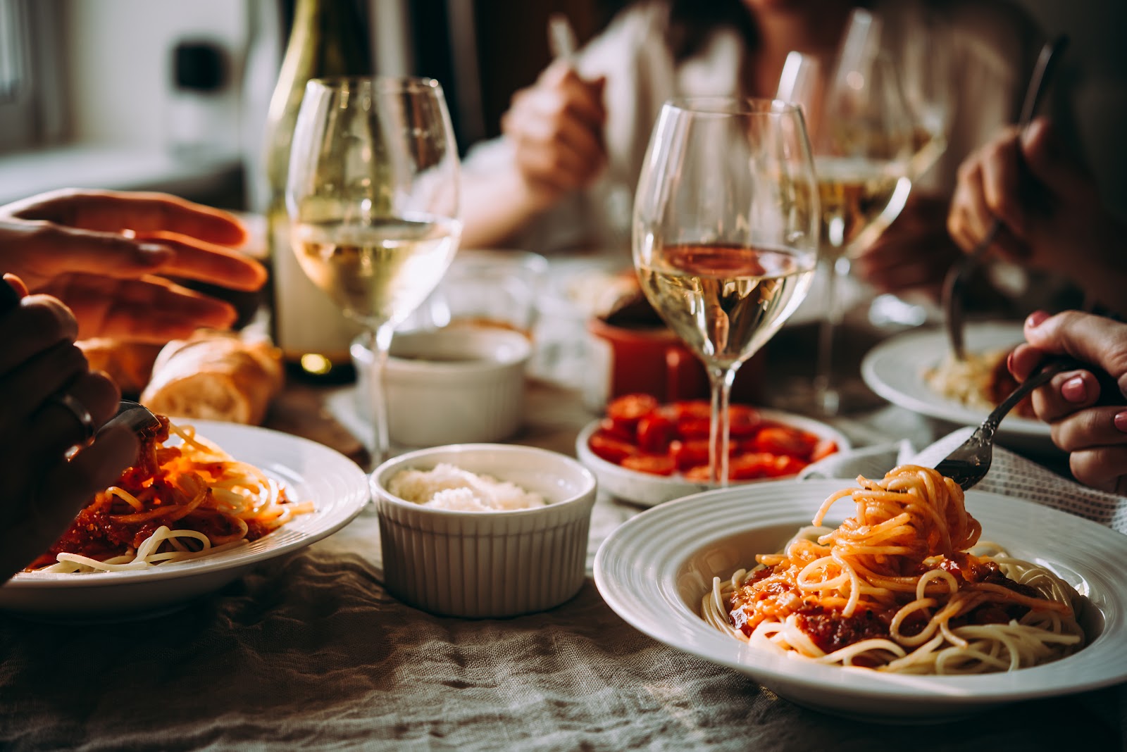 Italian dinner table set with pasta and wine glasses