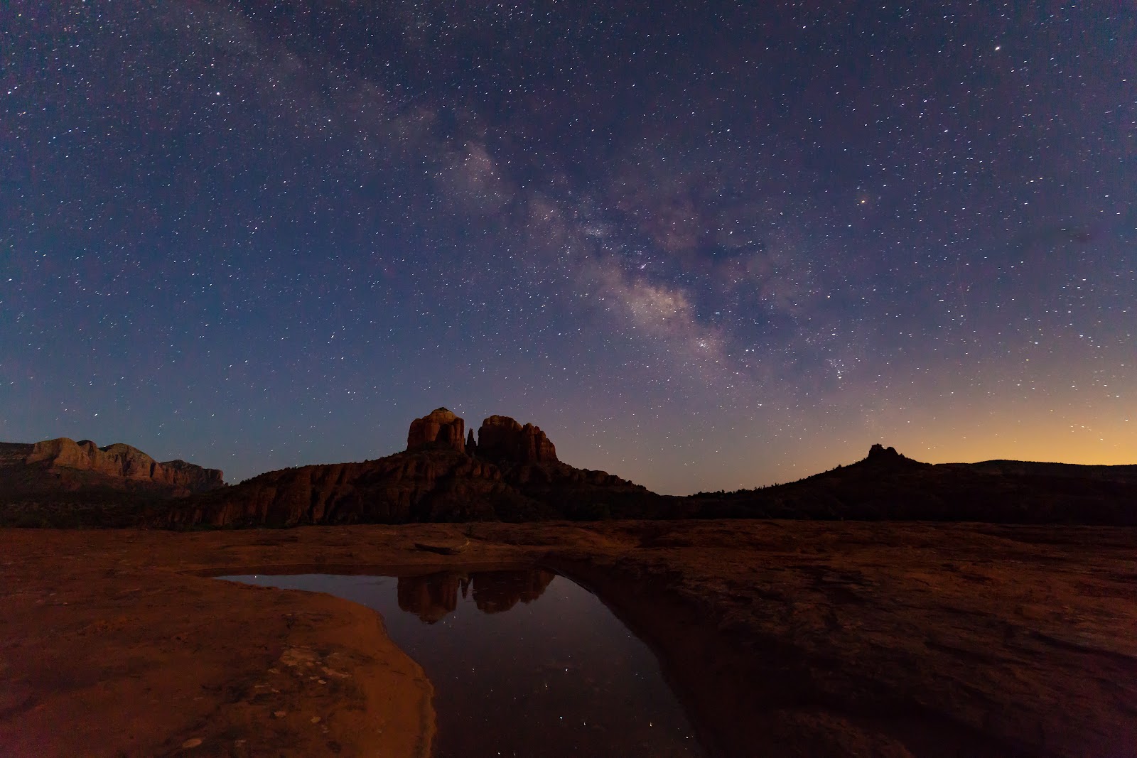 Milky Way over Sedona red rock formations reflected in still water
