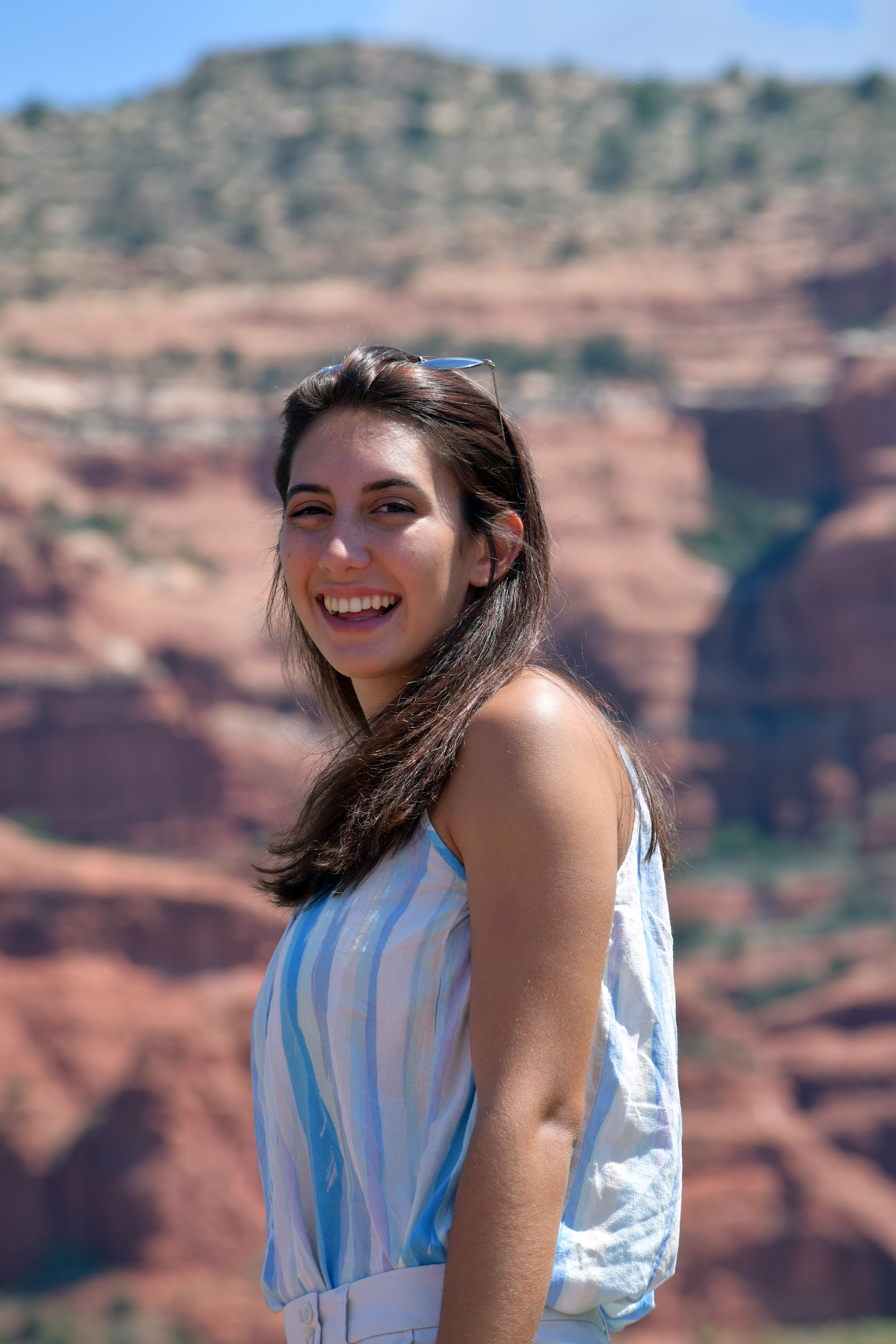 Visitor smiling at a red rock viewpoint in Sedona