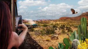 Sedona day trips: a passenger photographing red cliffs from the open-air car of the Verde Canyon Railroad